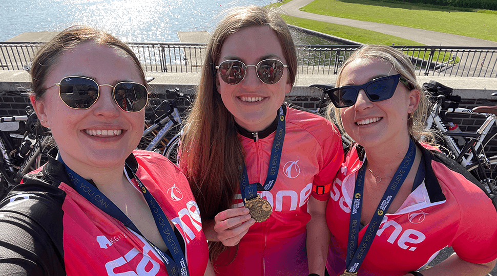 Three happy ladies showing their medals.